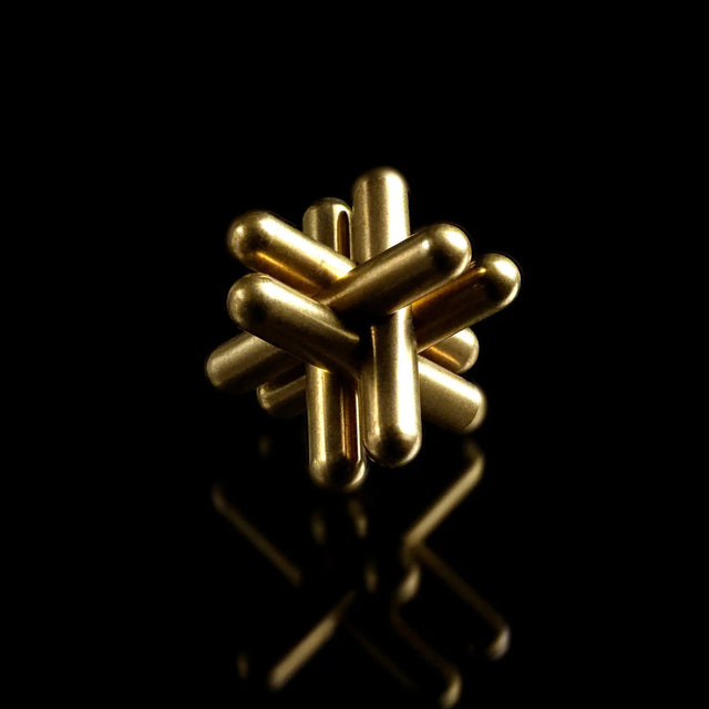 The fully assembled brass Curio Jack Puzzle on a black background