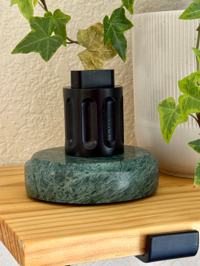 The black Curio Column Puzzle displayed on the Rajasthan Green marble Curio Plinth, lifestyle shelf shot with ivy plant