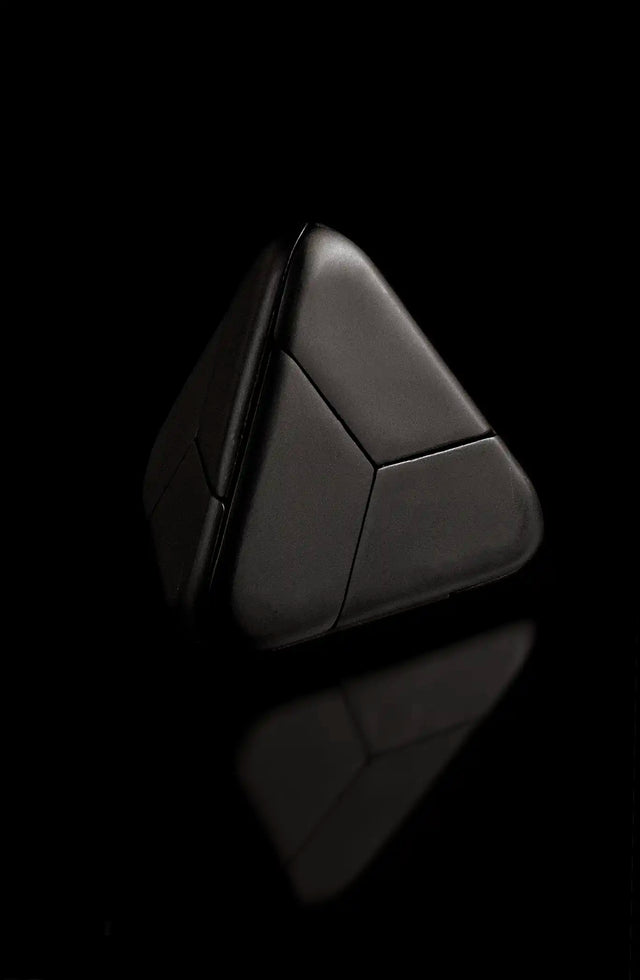 The black Curio Tetra Puzzle assembled on a black background