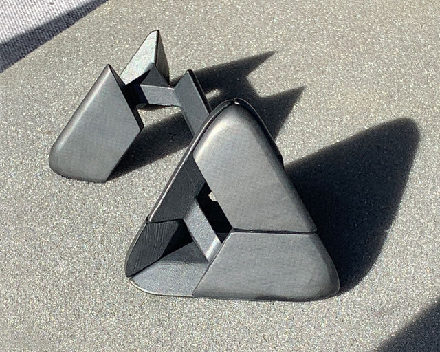The black Craighill Tetra Puzzle in its foam packaging insert