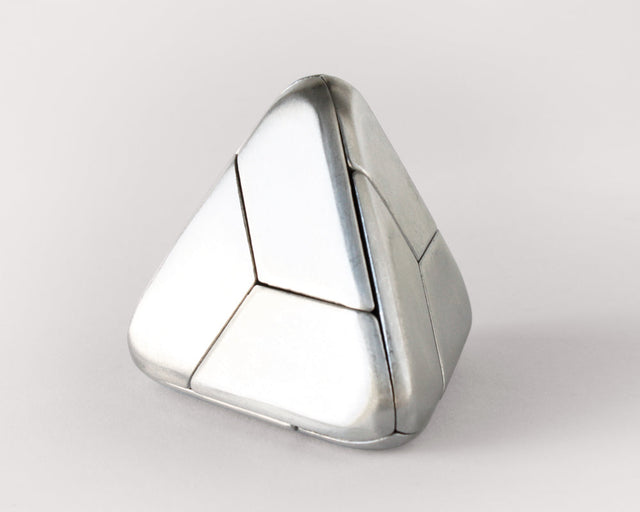 The stainless steel Craighill Tetra Puzzle fully assembled on a gray background