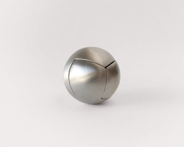 The stainless steel Craighill Venn Puzzle fully assembled on a gray background
