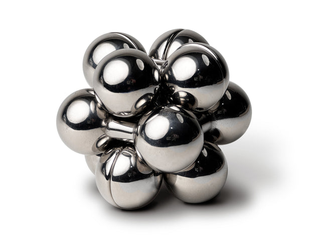 The silver Curio Atom Puzzle assembled on a white background