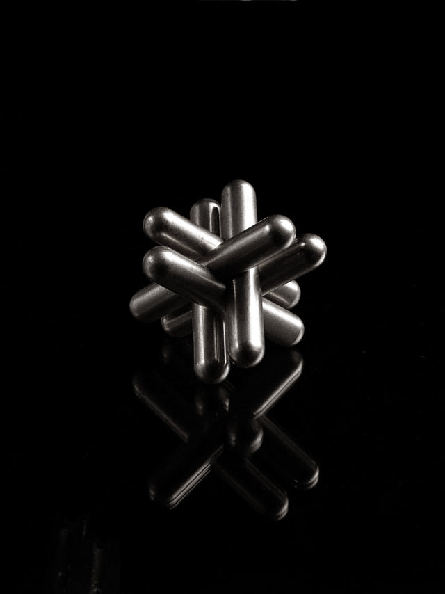 The stainless steel Craighill Jack Puzzle fully assembled on a black background