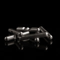 The stainless steel Craighill Jack Puzzle partially disassembled on a black background