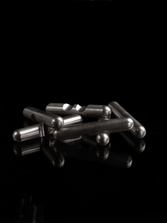 The stainless steel Craighill Jack Puzzle partially disassembled on a black background