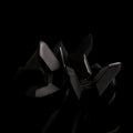 The black Curio Tetra Puzzle disassembled on a black background, angled view