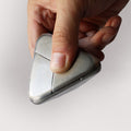 A hand assembling the stainless steel Craighill Tetra Puzzle on a gray background